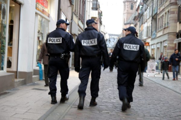 Trois policiers patrouillent à pied dans une rue de Strasbourg.